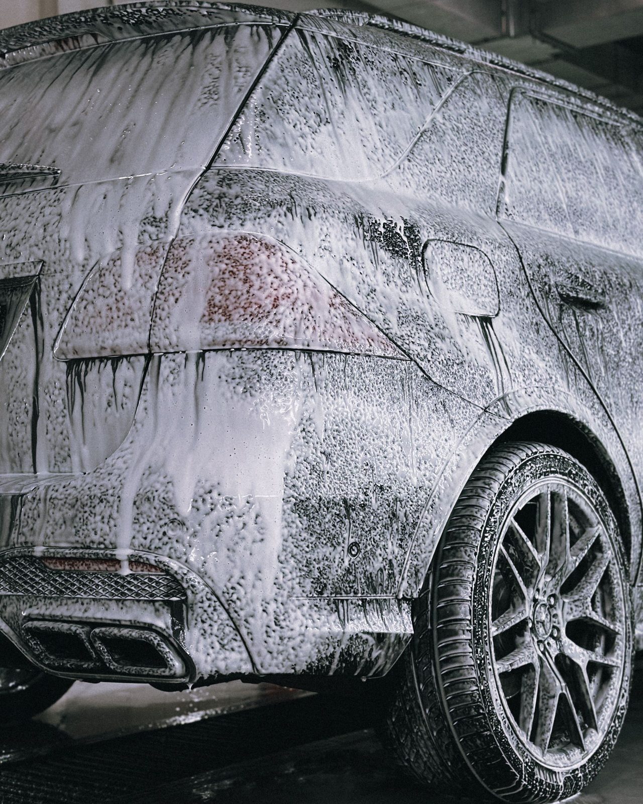 Detailer's hand-washed SUV covered in foam during a professional mobile detail