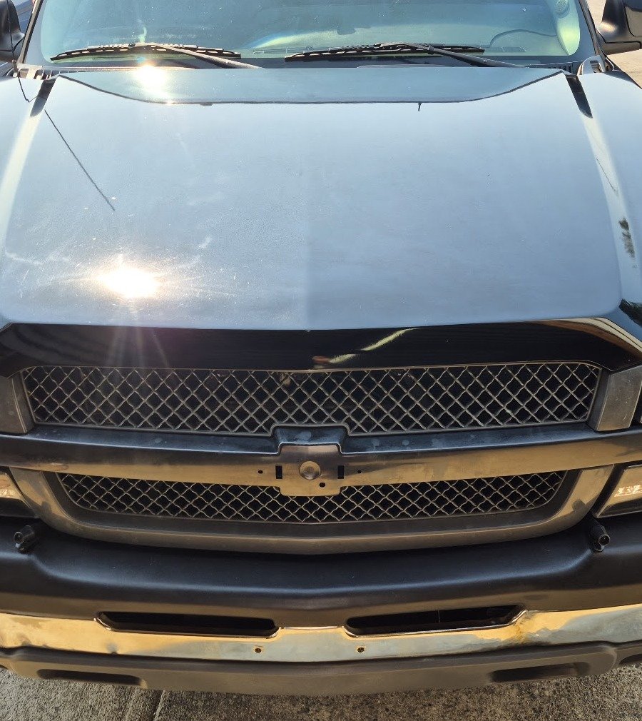 Glossy black truck hood and grille after an S&M Auto Detailing exterior wash and wax